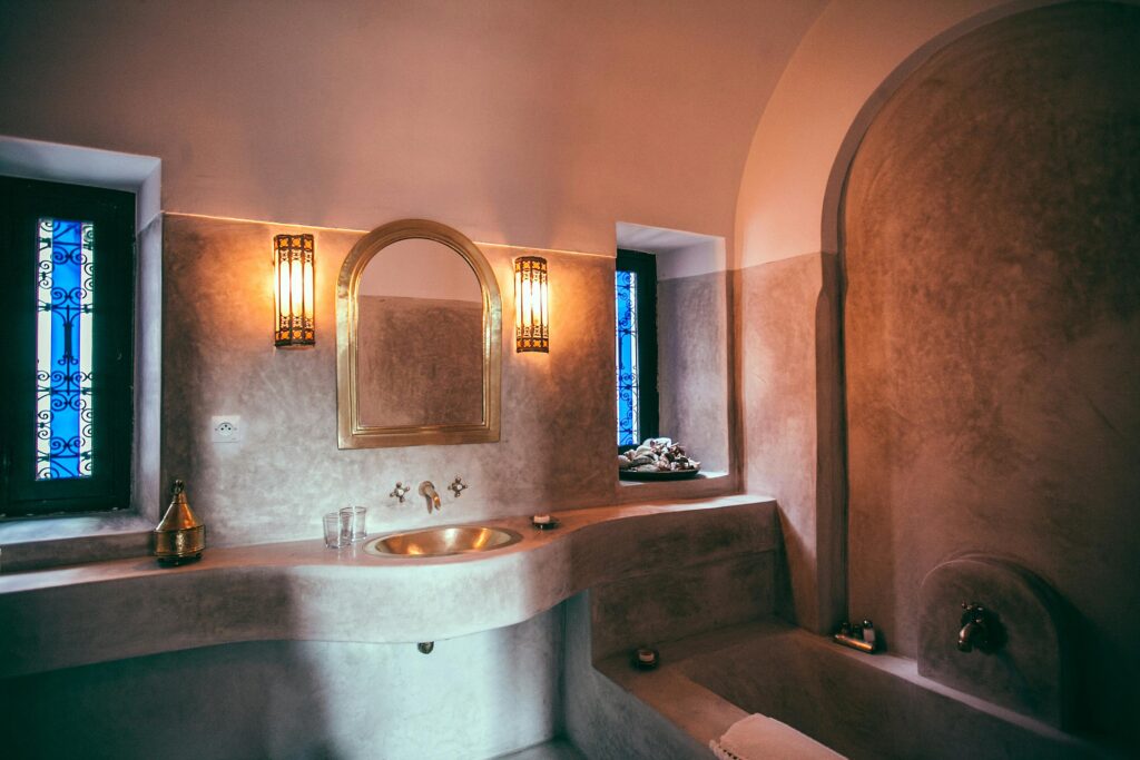 Interior design of modern spacious bathroom in Moroccan style with sink and bath made of stone