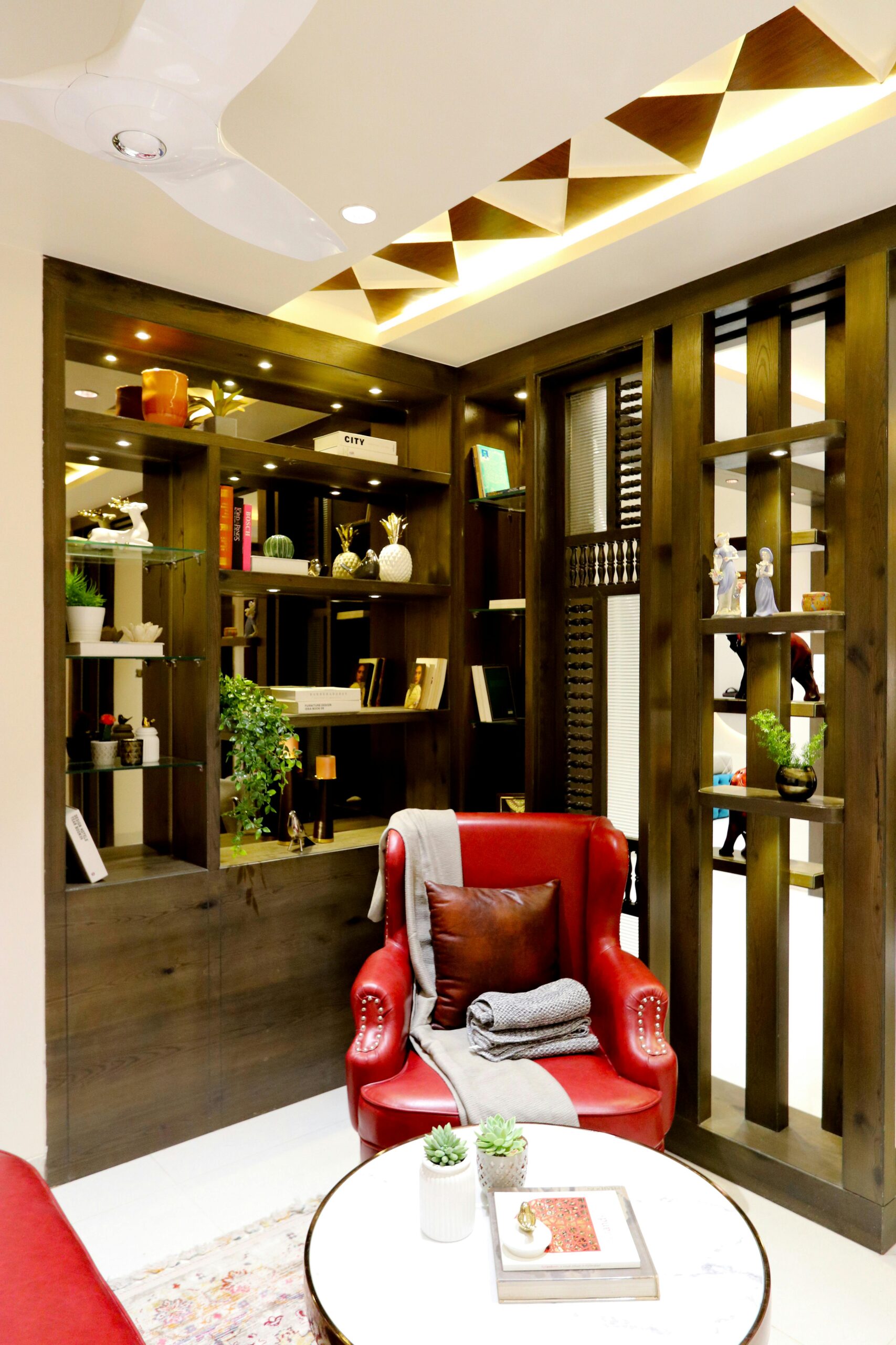 Elegant indoor setting featuring a vibrant red armchair and contemporary bookshelf design.